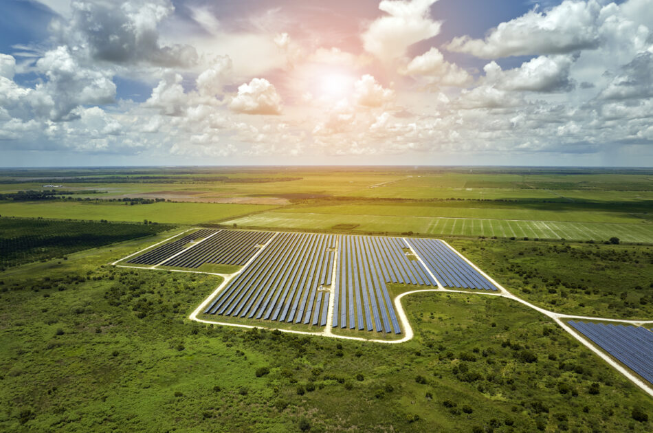 Aerial view of large sustainable electrical power plant with rows of solar photovoltaic panels for producing clean electric energy. Concept of renewable electricity with zero emission.